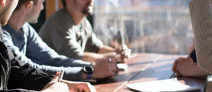 Men sitting around a table chatting.