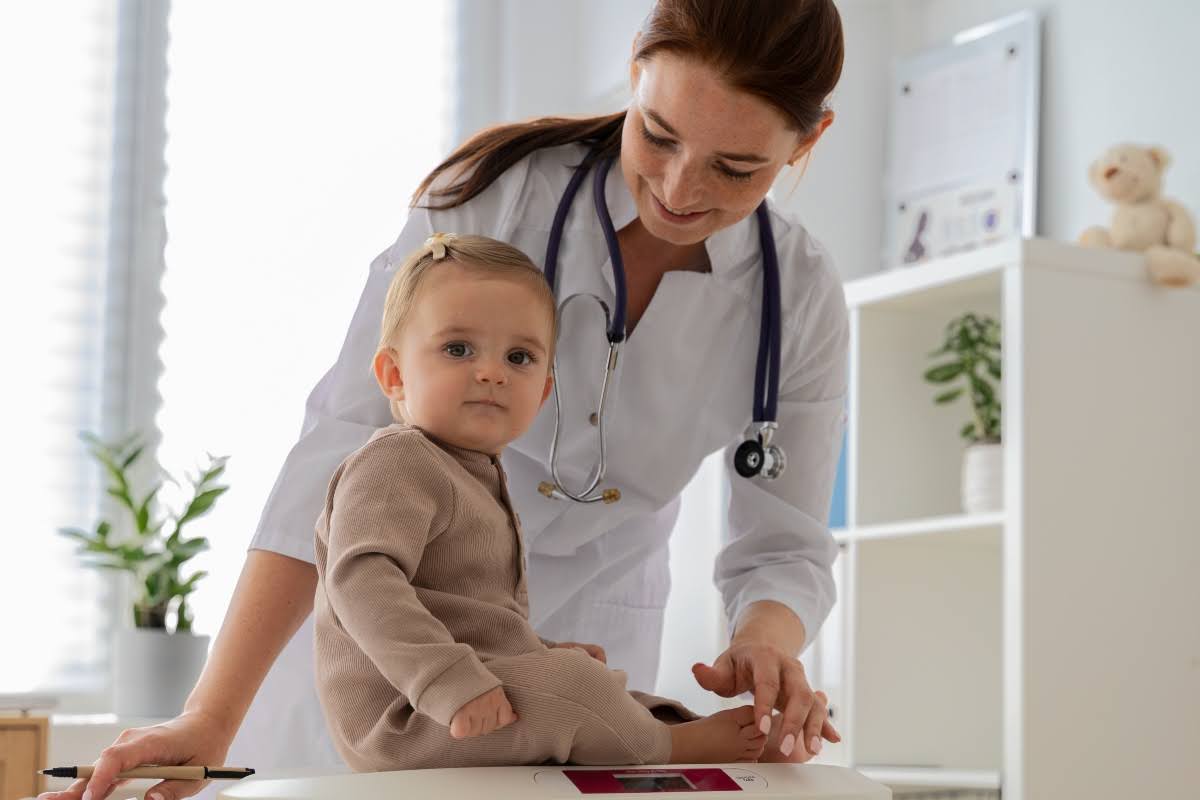 A pediatric nurse practitioner examining a baby.