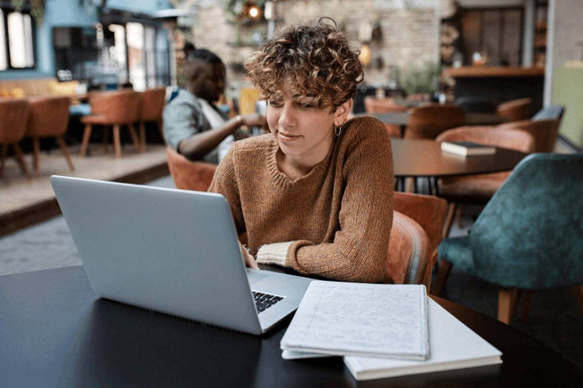 Student listening to an online lesson in a cafe.